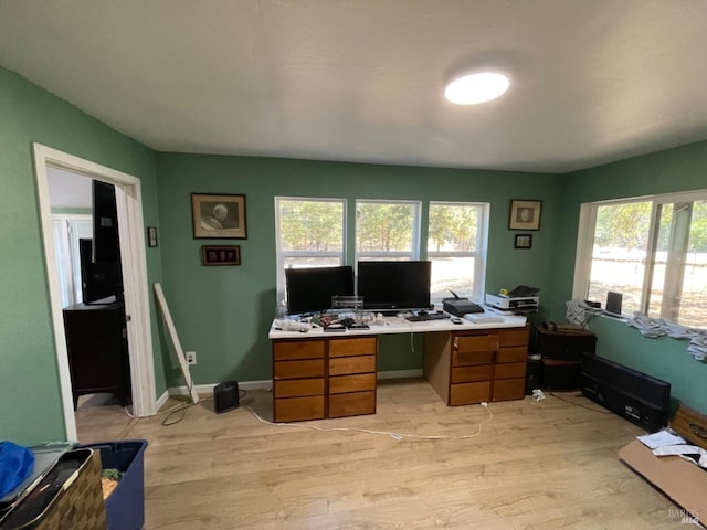 office area with light wood-style flooring, baseboards, and a wealth of natural light