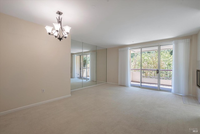 empty room featuring an inviting chandelier and light colored carpet