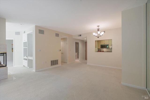 unfurnished room featuring an inviting chandelier and light carpet