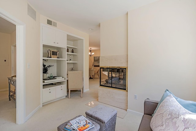 living area featuring light colored carpet, baseboards, visible vents, and an inviting chandelier