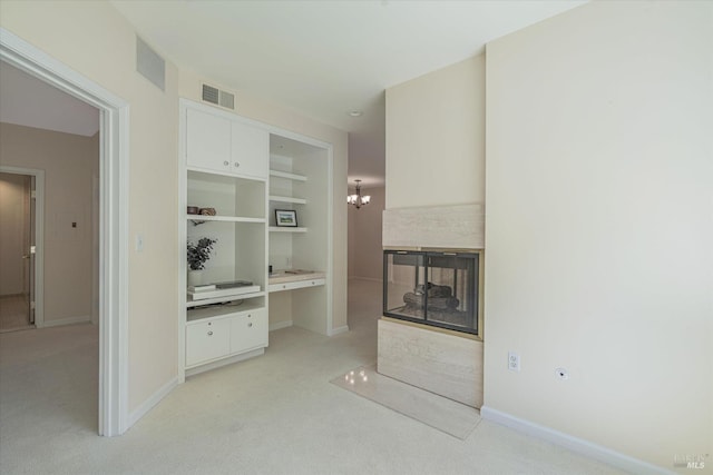 interior space with a multi sided fireplace, an inviting chandelier, and light colored carpet