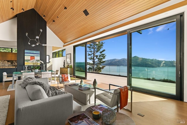 living room featuring expansive windows, light hardwood / wood-style floors, a water and mountain view, and wooden ceiling