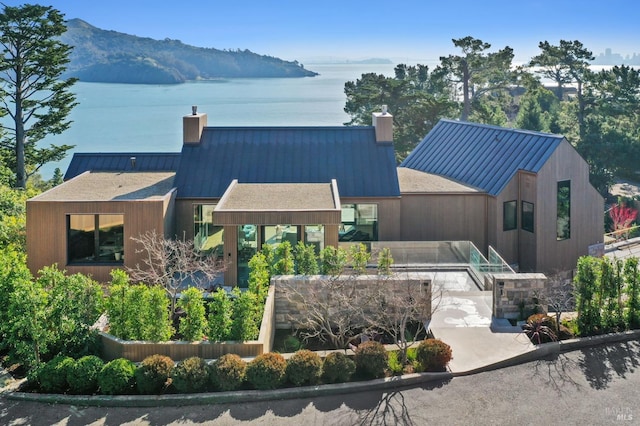 back of property with a water and mountain view