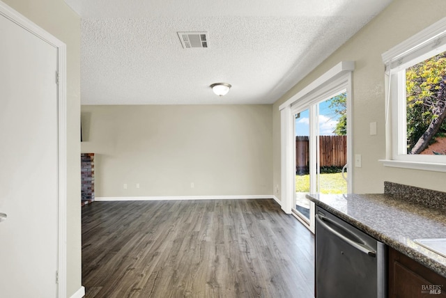 interior space with dishwasher, hardwood / wood-style floors, and a textured ceiling