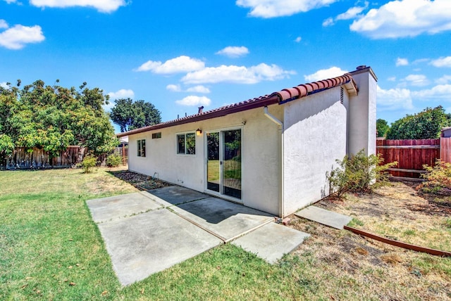 rear view of property with a yard and a patio area