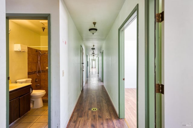 corridor featuring tile patterned flooring and baseboards