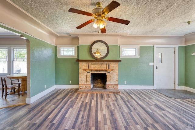 unfurnished living room featuring a textured ceiling, wood finished floors, and a healthy amount of sunlight