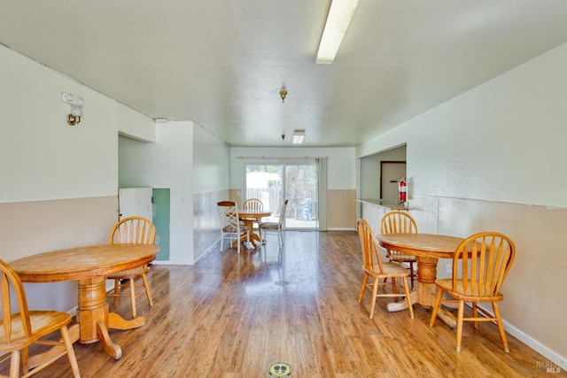 dining area featuring light wood-type flooring and baseboards