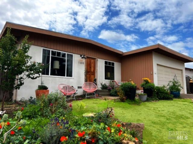 rear view of house with a garage and a yard