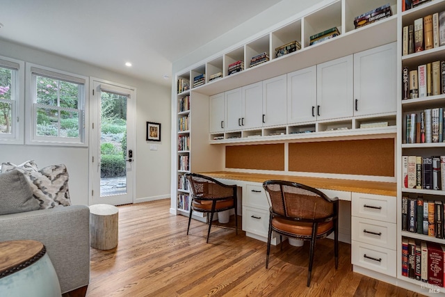 office featuring built in desk and light hardwood / wood-style flooring