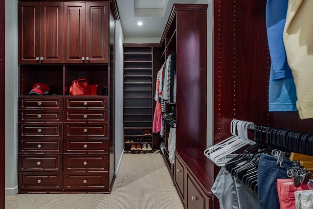 walk in closet featuring light colored carpet