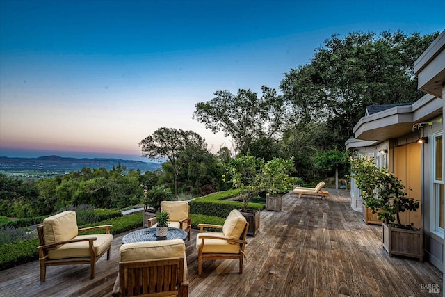 deck at dusk featuring an outdoor living space