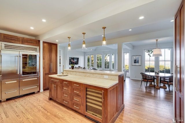 kitchen featuring hanging light fixtures, light hardwood / wood-style flooring, french doors, and a wealth of natural light