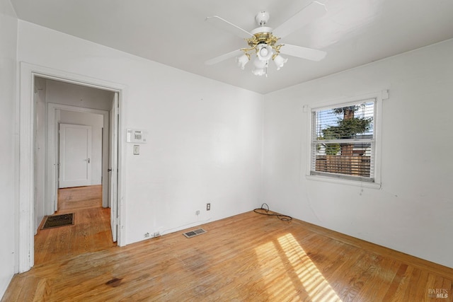 empty room with hardwood / wood-style floors and ceiling fan