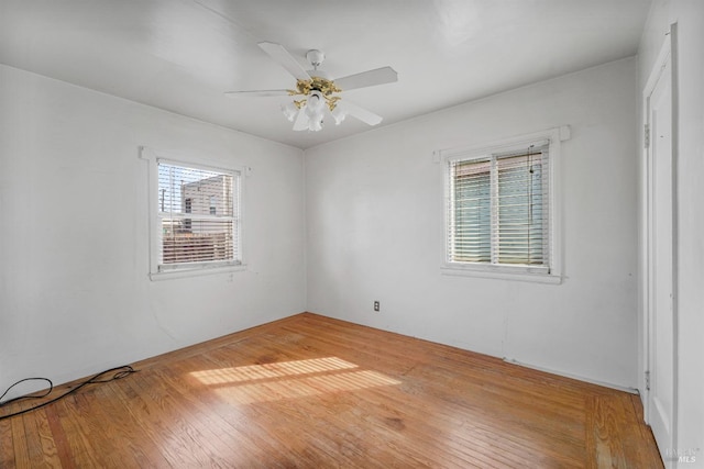 empty room with ceiling fan, hardwood / wood-style floors, and a healthy amount of sunlight