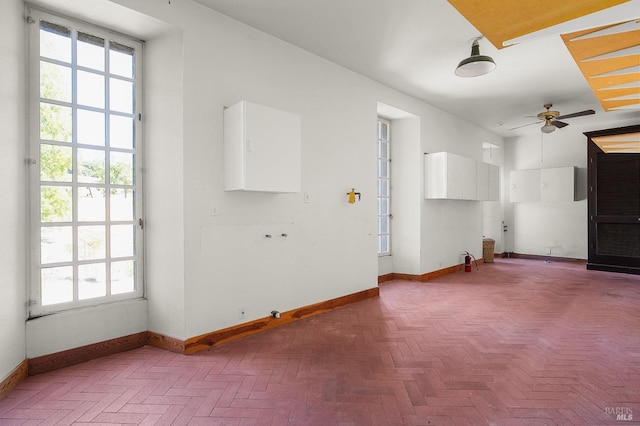 unfurnished living room with baseboards and ceiling fan