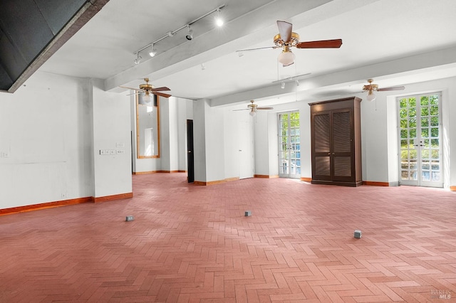 unfurnished living room with baseboards, a healthy amount of sunlight, and a ceiling fan