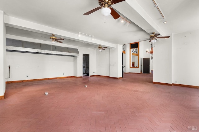 interior space with baseboards, track lighting, and a ceiling fan