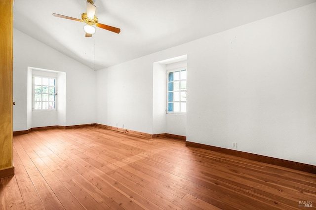 unfurnished room with hardwood / wood-style floors, vaulted ceiling, baseboards, and ceiling fan