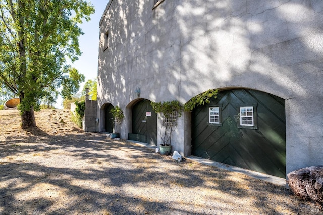 view of property exterior featuring stucco siding and gravel driveway