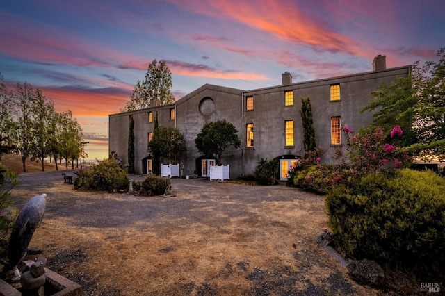 view of front facade featuring stucco siding and a chimney