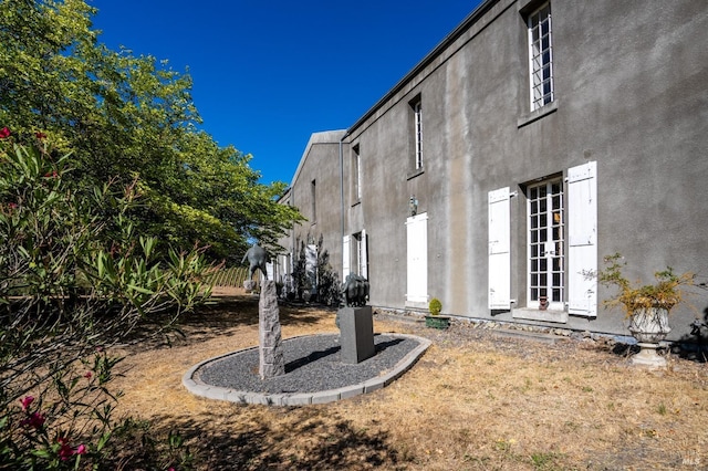 view of home's exterior with stucco siding and french doors