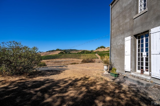 view of yard with a rural view and entry steps