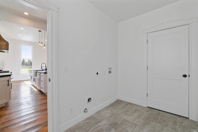 laundry area with hookup for an electric dryer, washer hookup, and sink