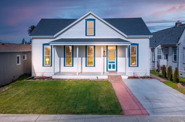 view of front of property with covered porch and a yard