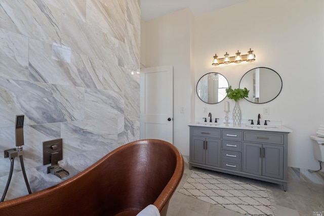 bathroom featuring tile patterned floors, a tub, vanity, and toilet