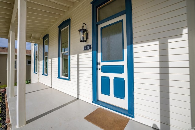 view of exterior entry featuring covered porch