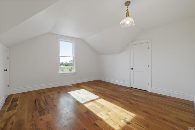 bonus room with hardwood / wood-style flooring and vaulted ceiling