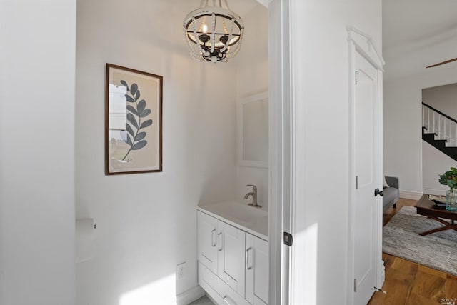 bathroom with hardwood / wood-style floors, vanity, and a chandelier