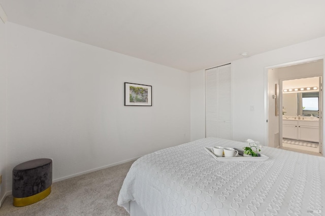 bedroom featuring light colored carpet and ensuite bath