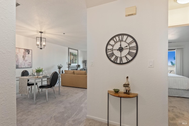 carpeted dining space with an inviting chandelier