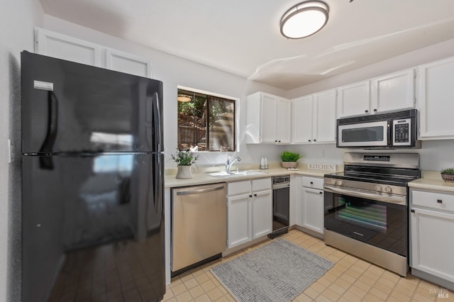 kitchen with light tile patterned floors, sink, white cabinets, and stainless steel appliances