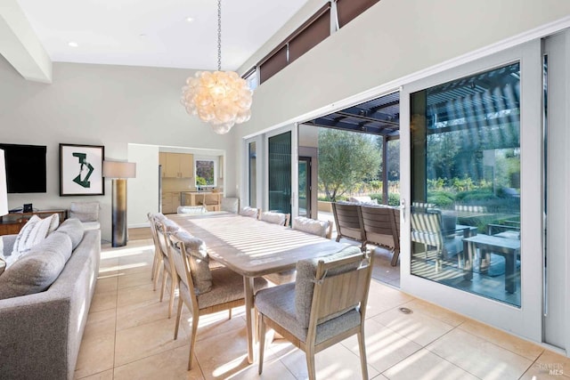 tiled dining room featuring high vaulted ceiling and an inviting chandelier