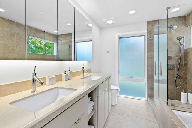 full bathroom with tile patterned floors, toilet, shower with separate bathtub, and vanity