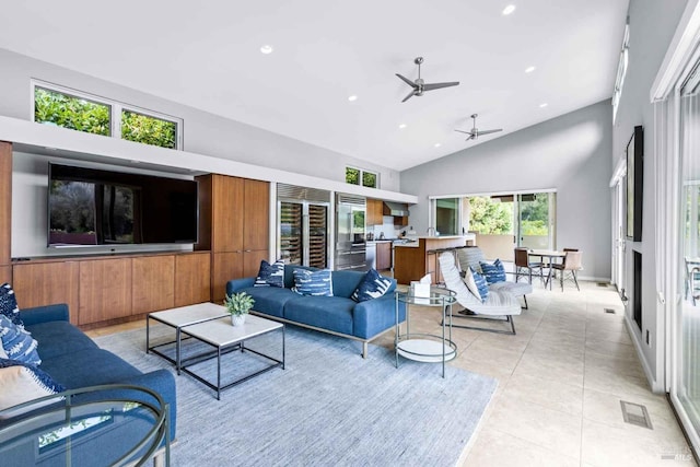 living room featuring plenty of natural light, ceiling fan, high vaulted ceiling, and light tile patterned floors