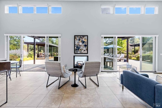 dining area with a wealth of natural light, light tile patterned floors, and a towering ceiling