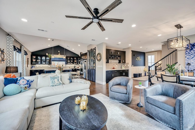 living area with recessed lighting, bar, visible vents, vaulted ceiling, and dark wood finished floors