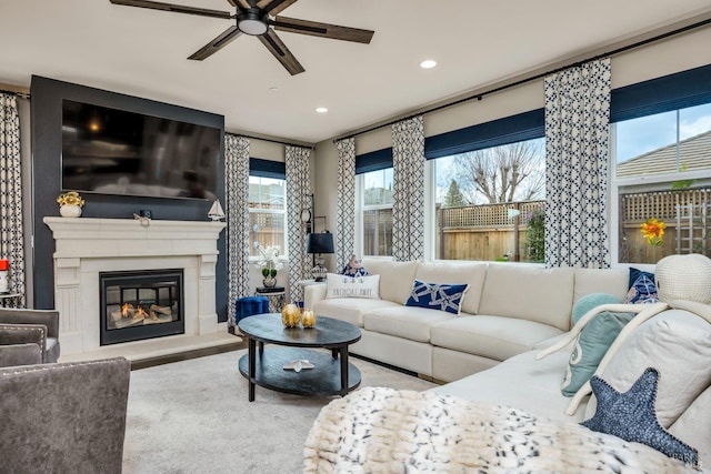 living room featuring ceiling fan and a large fireplace