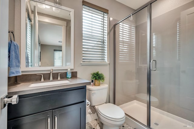 bathroom featuring vanity, toilet, and walk in shower