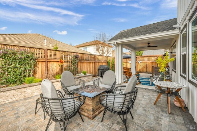 view of patio / terrace featuring a grill, ceiling fan, and a fire pit