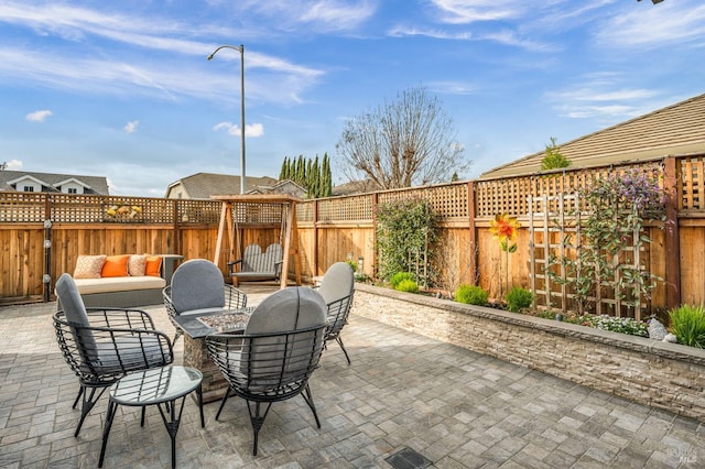 view of patio with an outdoor living space with a fire pit