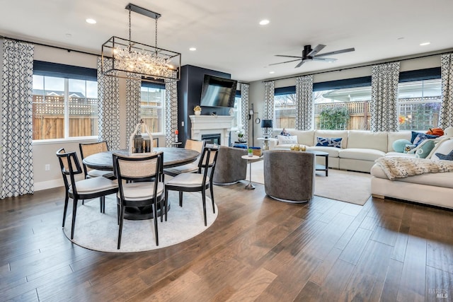 dining space featuring dark hardwood / wood-style flooring and ceiling fan with notable chandelier