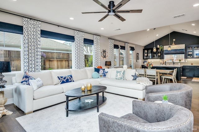 living room with ceiling fan, wood-type flooring, and lofted ceiling