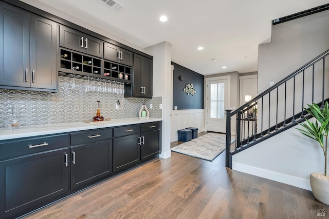 bar featuring tasteful backsplash and hardwood / wood-style flooring