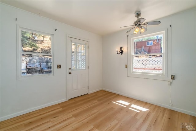 doorway to outside with light hardwood / wood-style flooring and ceiling fan