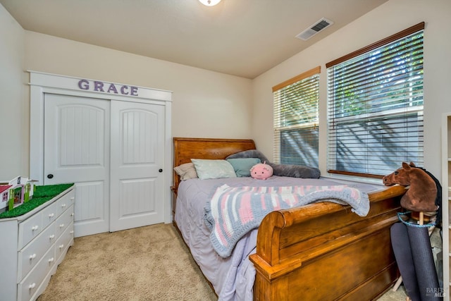 bedroom featuring light colored carpet and a closet